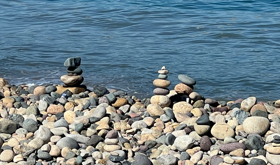 Equilibrio interior y sanación energética representados por piedras en calma junto al agua